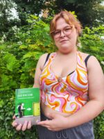 Eine Person hält das Buch "exit RACISM: rassismuskritisch denken lernen" in der Hand.