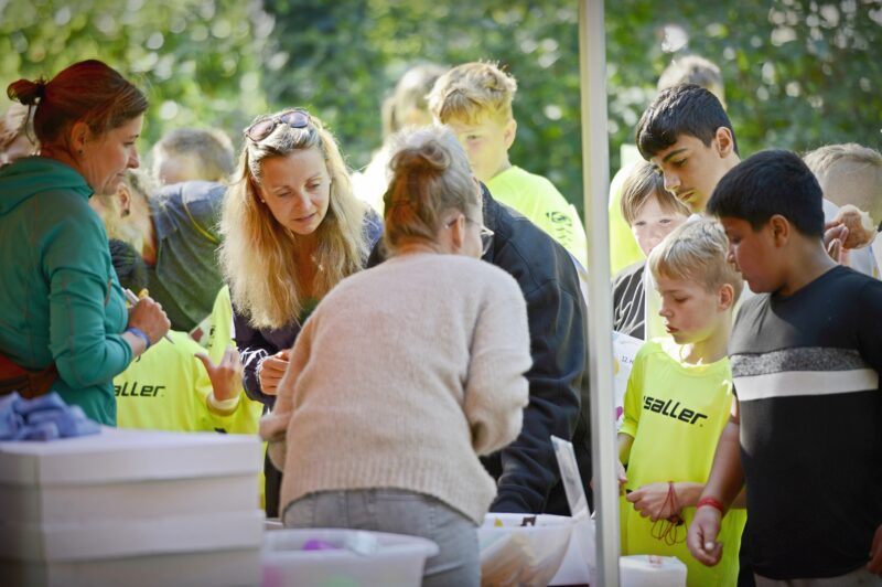 Eine Gruppe Personen steht an einem Infostand.