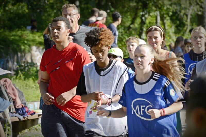 Eine laufende Gruppe Personen in Sporttrikots.