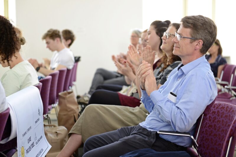 Personen im Publikum applaudieren.